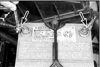 1. Отверните гайки и отсоедините клеммы (стрелки) от полюсов (первой отсоединяется