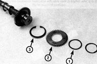 16. Снимите пружинную шайбу (1), вспомогательную шестерню (2) и пружину вспомогательной