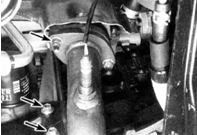 4. Отверните верхний болт (верхняя стрелка) крепления стойки выпускного коллектора