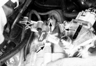 19. Открутите болты (указаны стрелками) зажимов трубок охлаждающей жидкости.