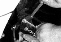 3. Открутите две гайки крепления (указаны стрелкой) стойки к поворотному кулаку