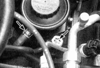 7. Освободите хомут (указан левой стрелкой) и отсоедините шланг обратного трубопровода