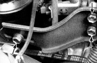 12. Снимите шарнирный, регулировочный болт (указан левой стрелкой) и два болта