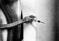 3. Отвинтите болт распорки (указан стрелкой) ограничителя открывания двери.