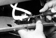 2. Открепите разъем от держателей и снимите бардачок. (Не отсоединяйте разъем